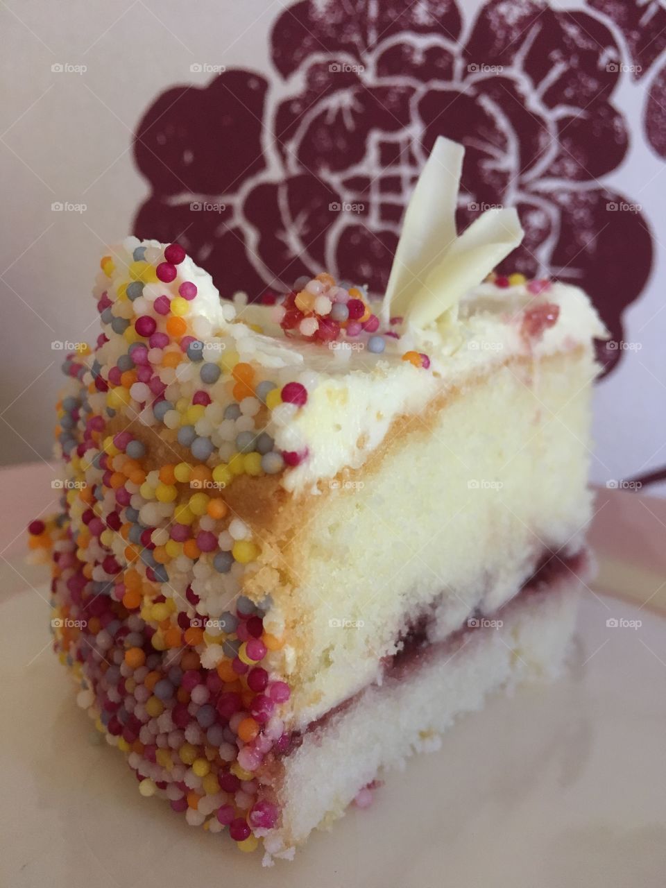 Close up view of gluten free Victoria sponge cake with vanilla frosting and sprinkles 