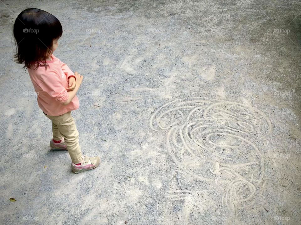 A girl looking at her own drawing