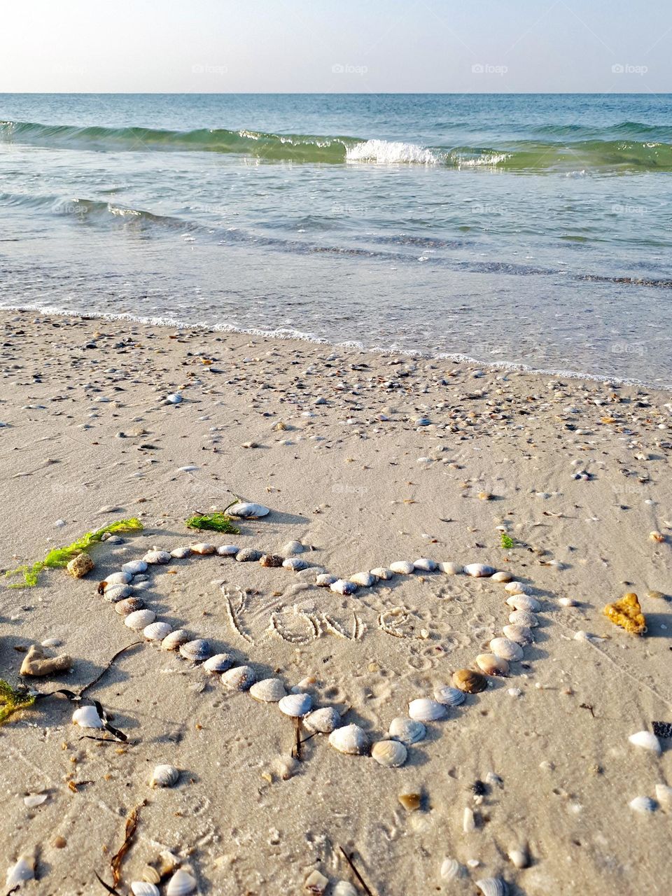 Heart from shells on the beach. Romantic vacation 
