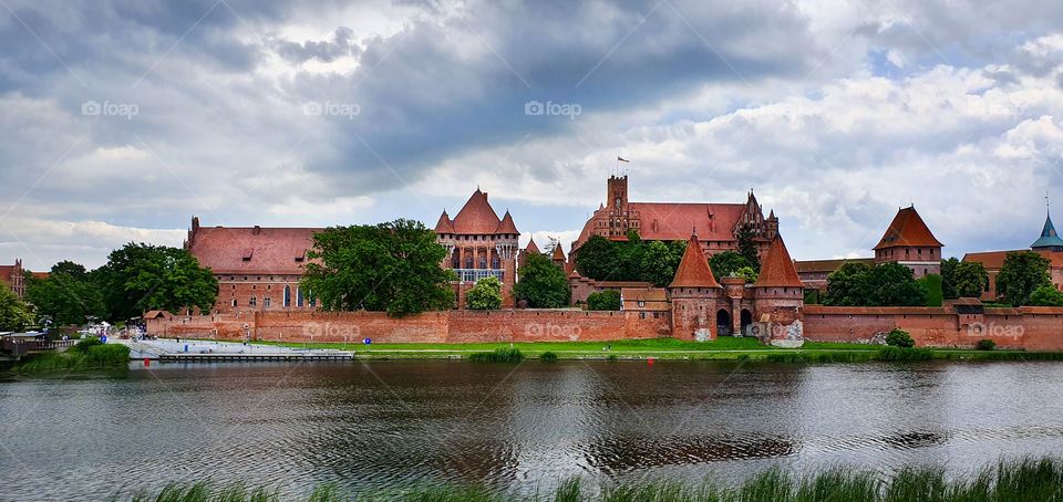 Historical castle of the Teutonic Order in Malbork seeing from the other side of river Nogat