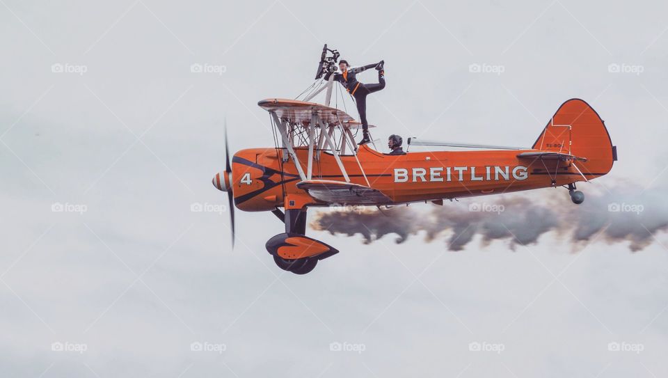 orange  Breitling  bi-plane with wingwalker