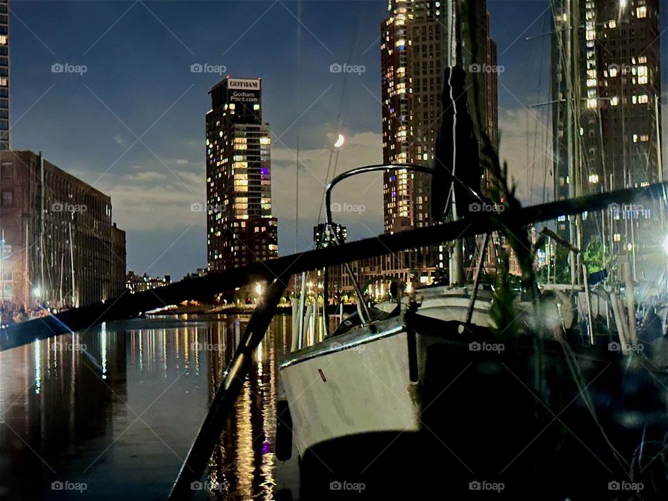 At night “Newtown Creek” by the “Pulaski Bridge” in LIC, Queens is illuminated only by a sichel moon, the electric lights of surrounding high rises in LIC and “Greenpoint”, Bklyn and the reflections in the “East River”. 2024. Hypnotic Productions