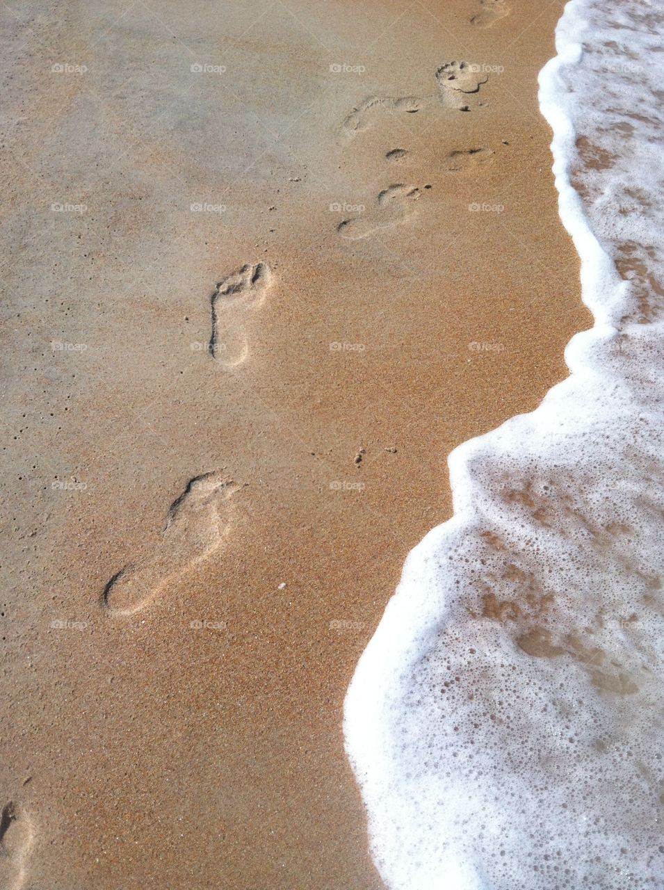Footprints in sand. Walking on the beach 