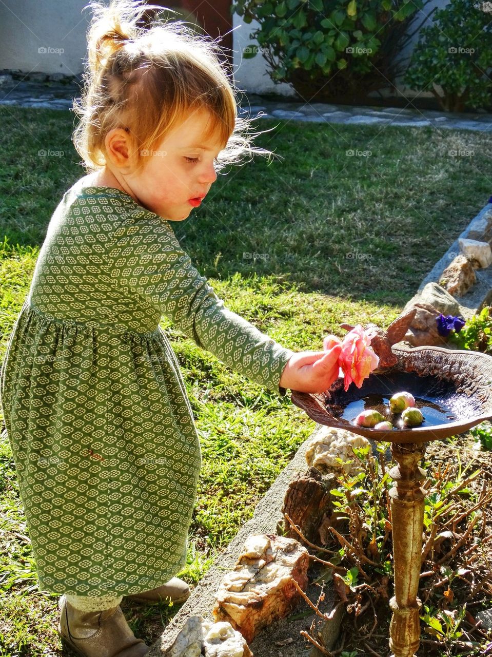 Child Decorating A Bird Bath
