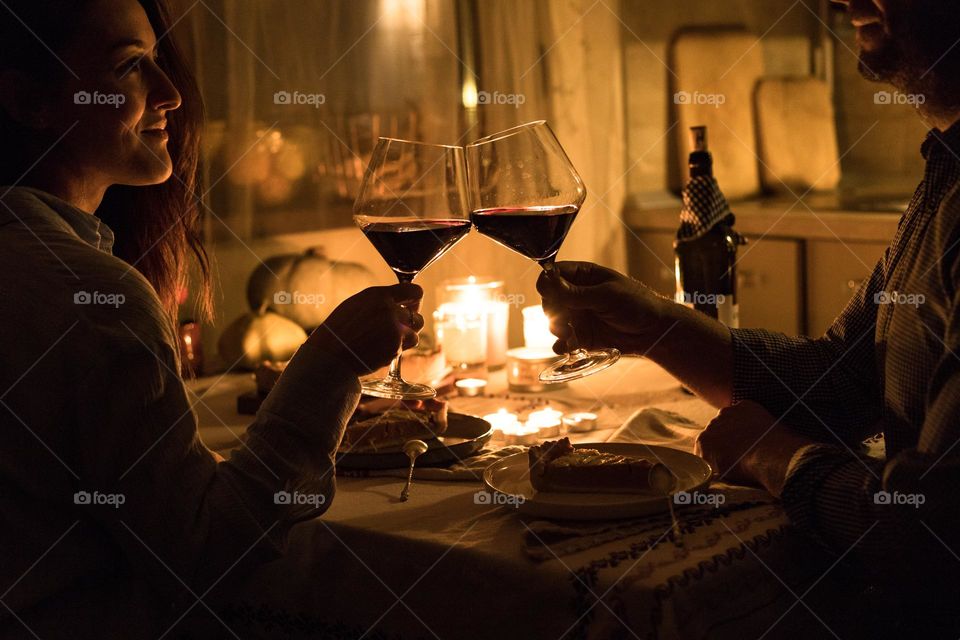 Couples having a romantic dinner at home, drinking wine, being happy.