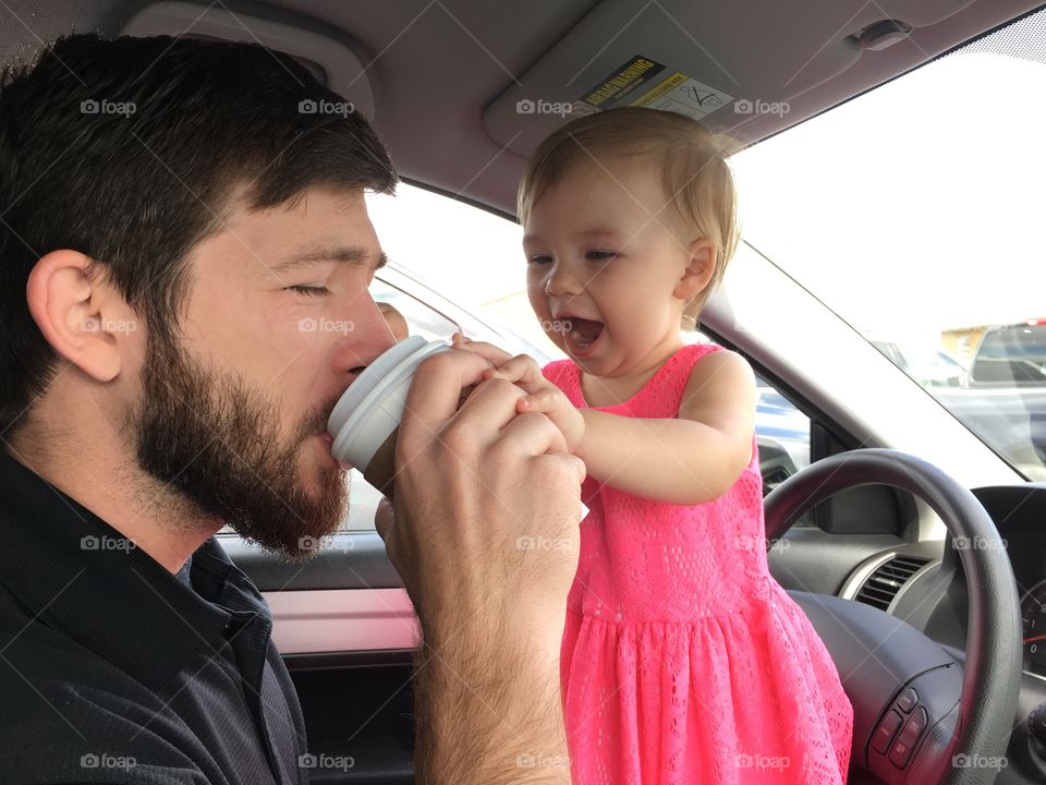 Man drinking cold drink with his daughter