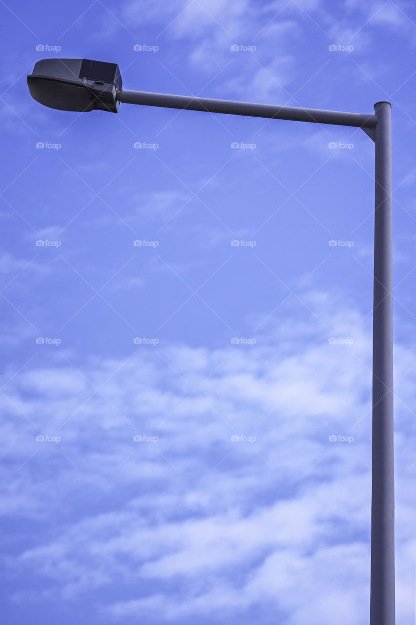 Close up shot of a single street light with a clear blue sky in the background.