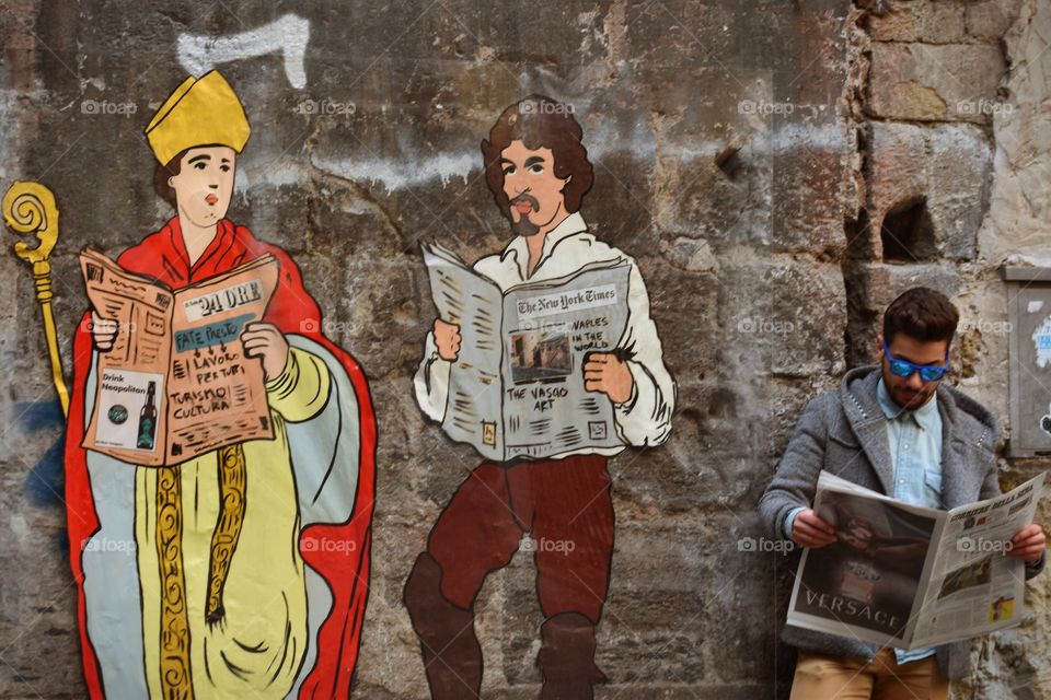 street art from naples - A conversation between two friends: San Gennaro and Caravaggio and the man reading the newspaper
