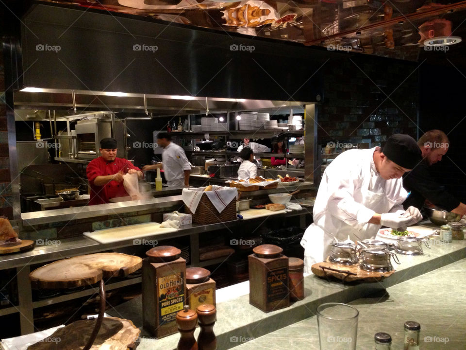 Chef cutting prosciutto in restaurant's kitchen
