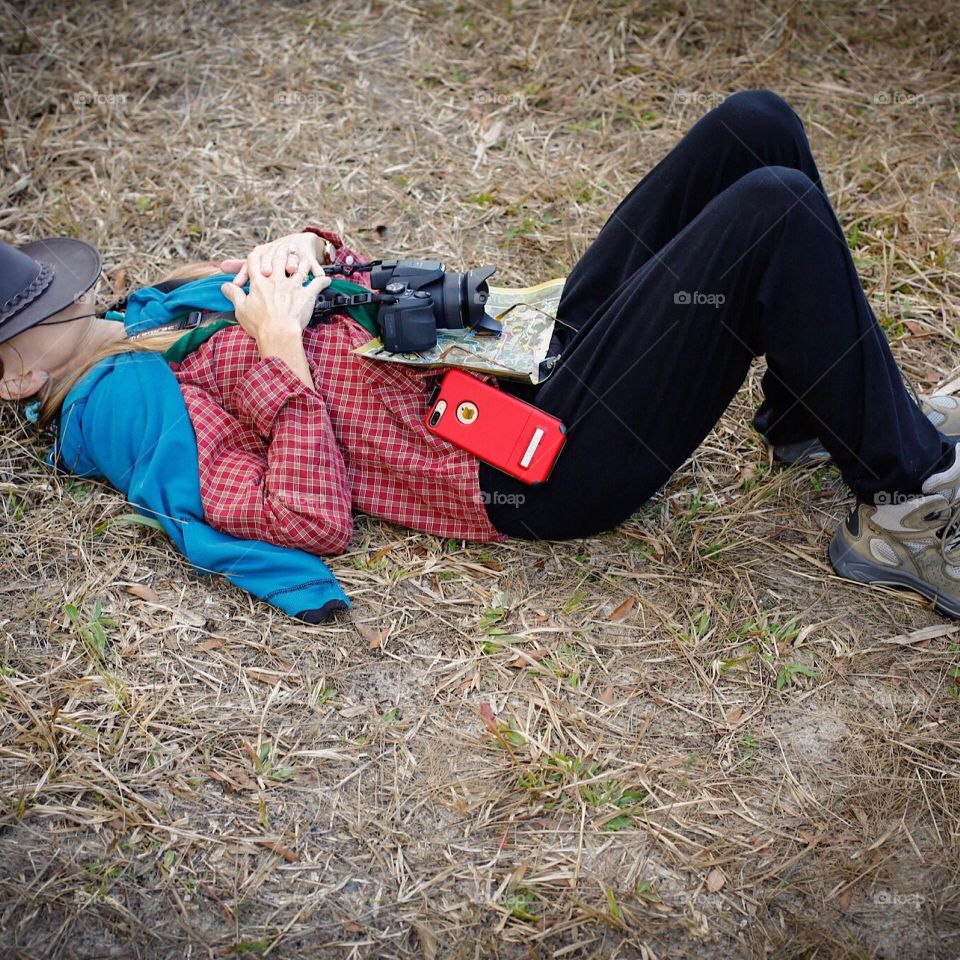 Woman resting on the grass after a strenuous hike.