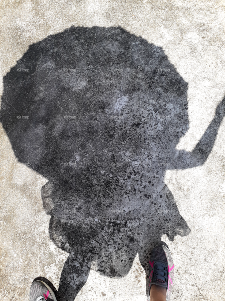 A shadow of an umbrella and the woman  holding it, under the Sun shine of summer day.