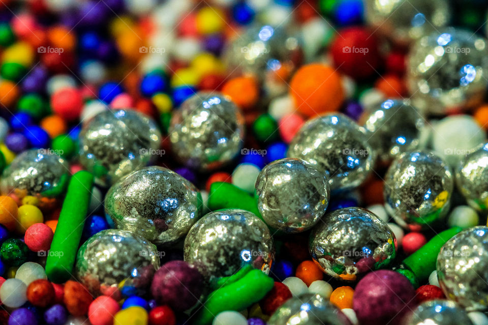 A macro shot of candy sprinkles of every colour including silver dragees that reflect light & more colour from the sprinkles. A feast for the eyes & the tummy when topped on cupcakes & cookies! Yumm! 😁