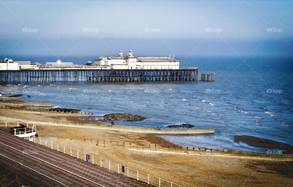 A view from high up of the old Hastings Pier, seafront and beach