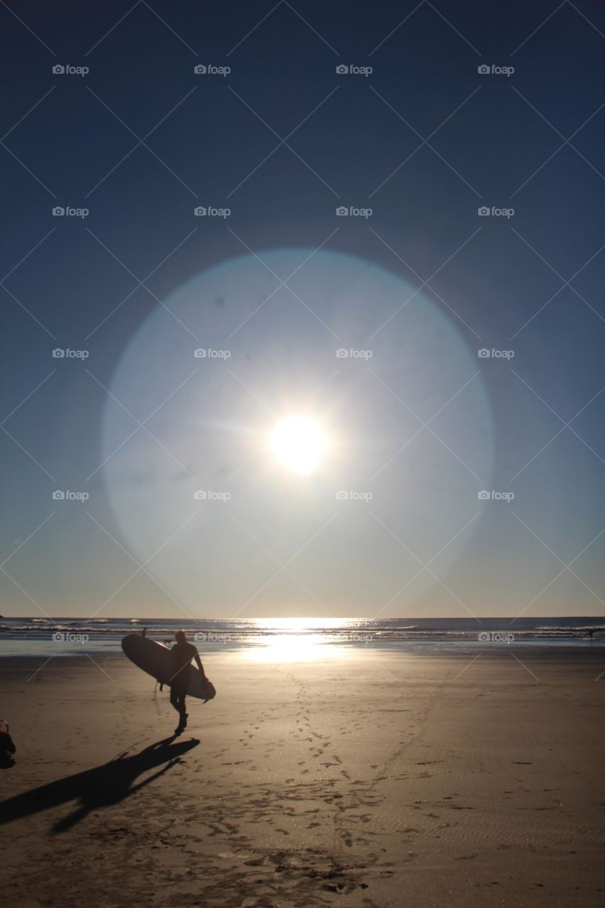 Surfer walking from the sun