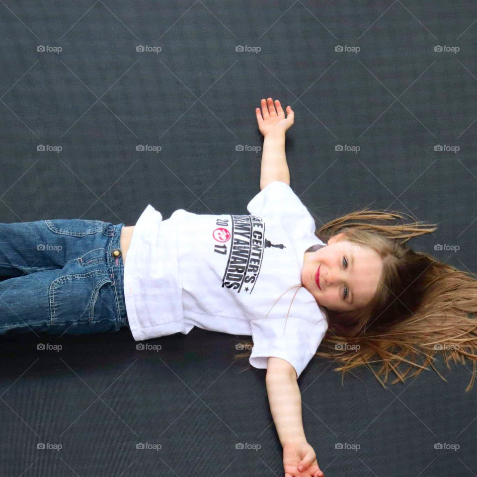 girl laying on a trampoline