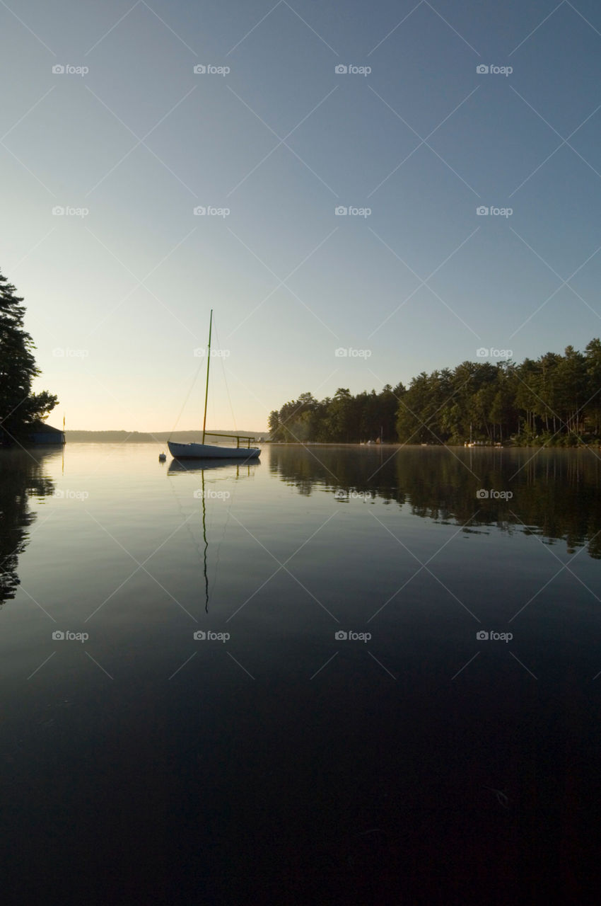 Sailboat on a serene cove at sunset