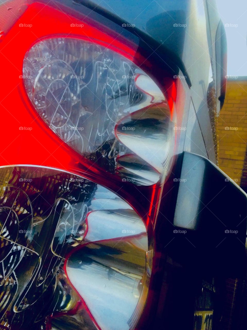 Another view of the parked red sportscar in LIC, Queens with the style and the looks of a Ferrari or a Porsche. Seen from unusual angles realistic objects can take on a look that is surreal. 2020. Hypnotic Productions