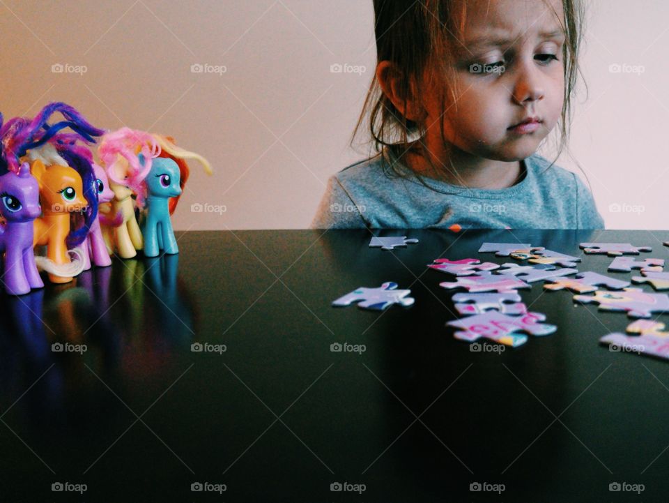 Little girl playing puzzle game