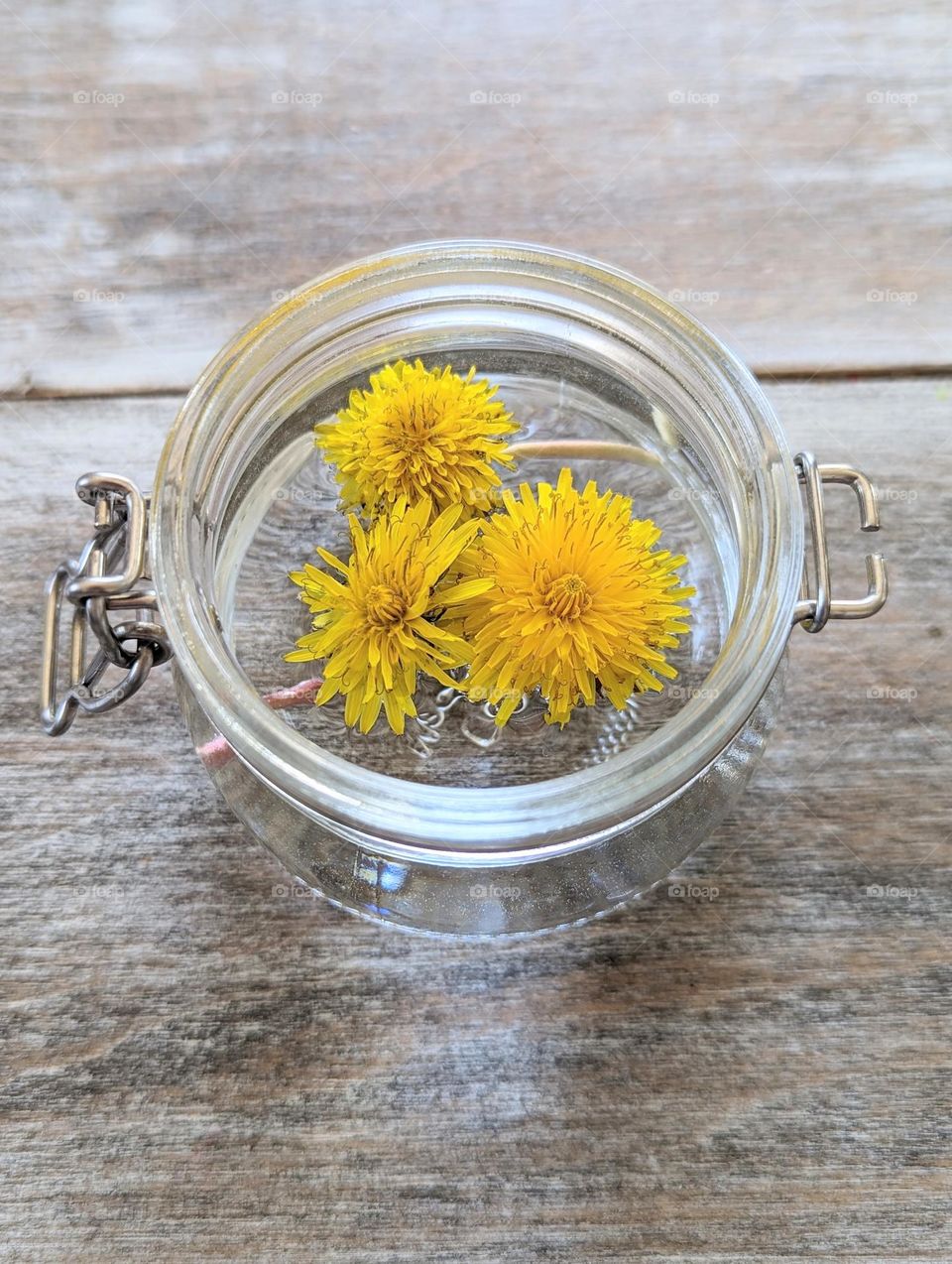 freshly picked yellow dandelions in small glass jar as a dining table centerpiece