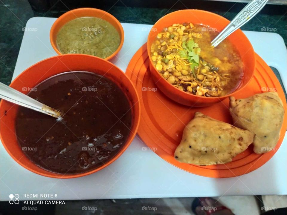 Samosa chola: A samosa is a South Asian fried or baked pastry with a savory filling like spiced potatoes, onions, peas, beef and other meats, or lentils. It may take different forms, including triangular, cone, or half-moon shapes.