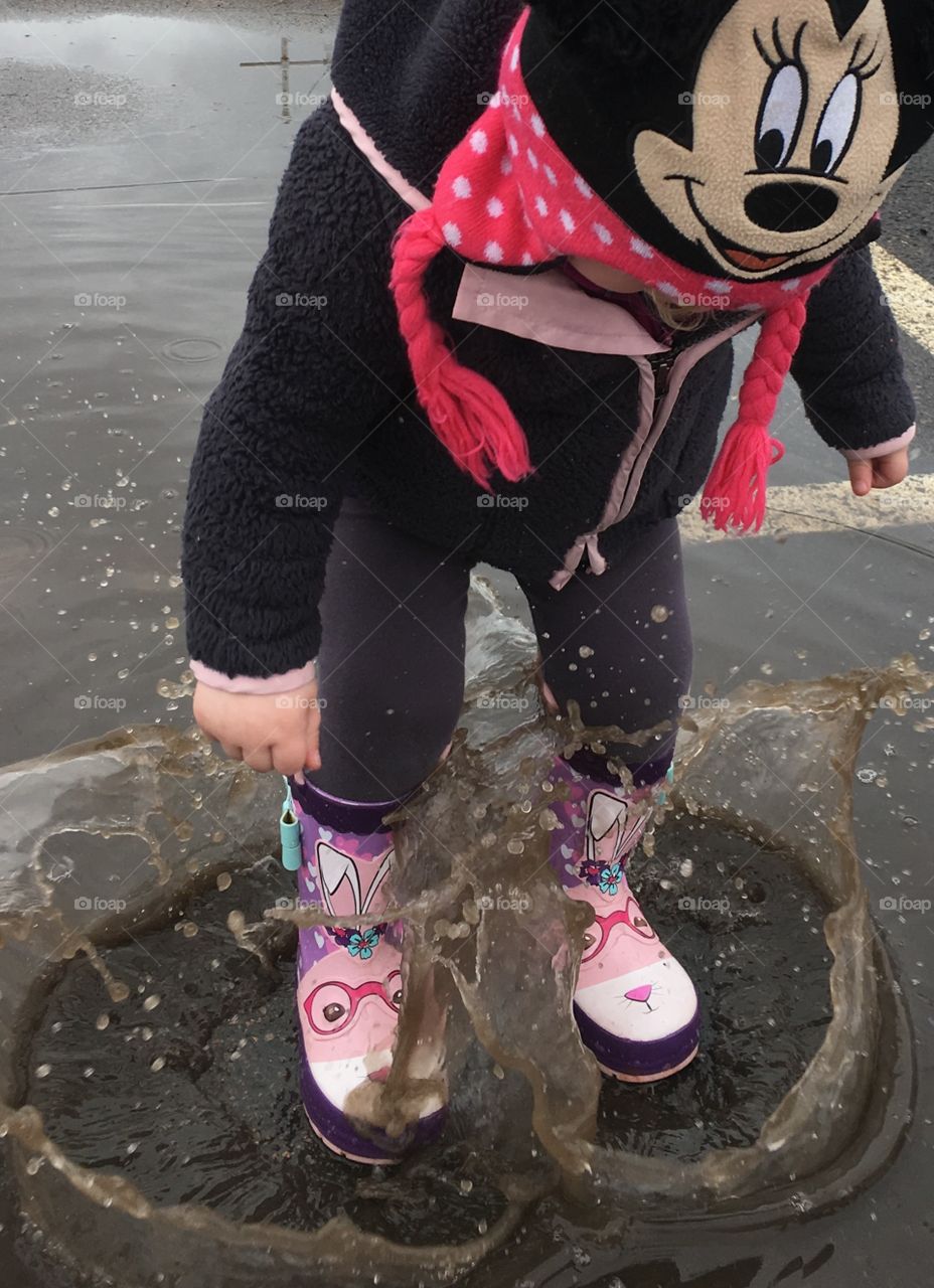Girl jumping in puddles