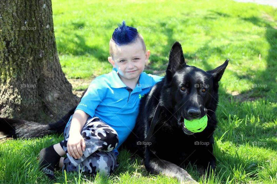My sweet blue haired little boy giving his dog some love on a sunny summer afternoon. 