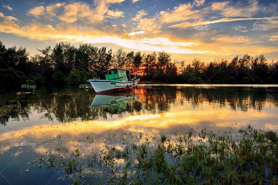 Reflections of boat and the sky during sunset