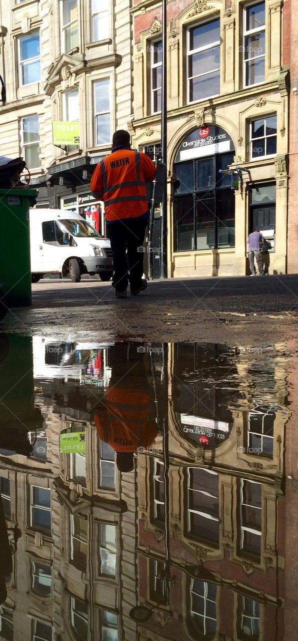 Photo of a burst pipe flood in a city street … taken really low to the ground to show a deep reflection