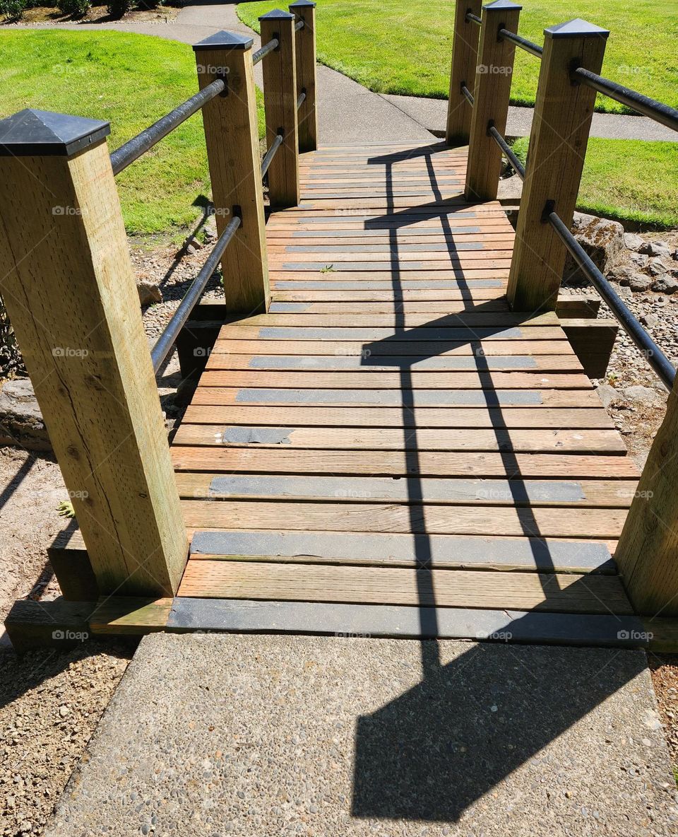 wooden bridge casting a shadow in a Suburban Oregon Apartment complex on a sunny day