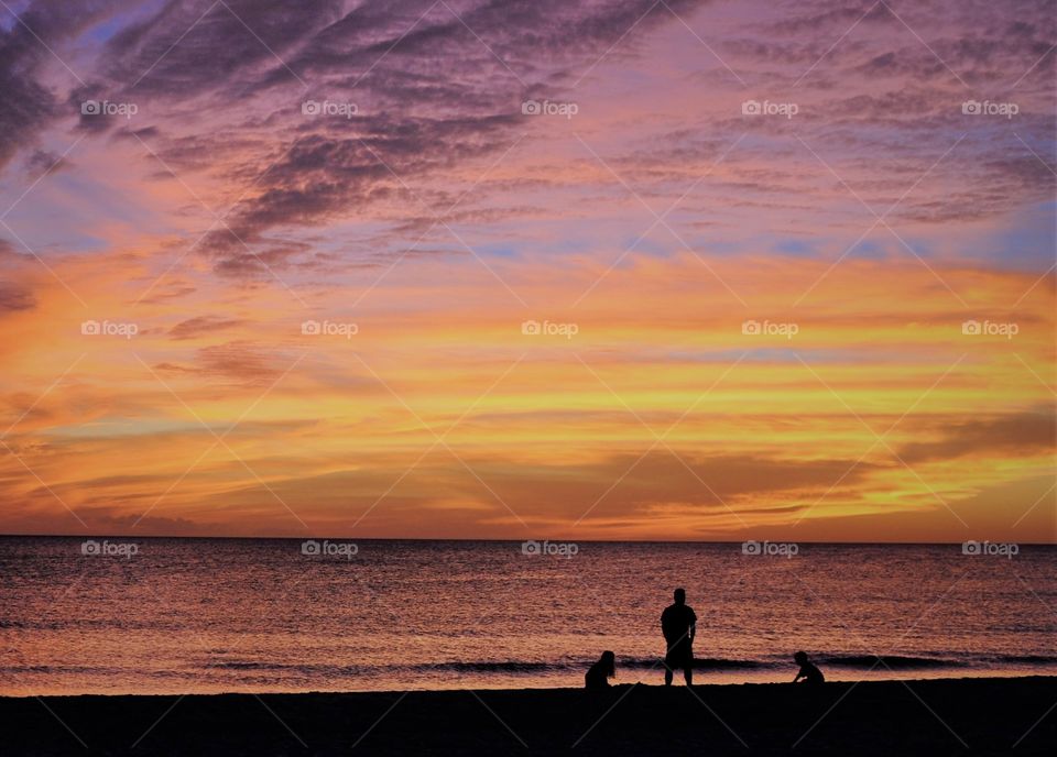 Sunset with a man and his children on the beach