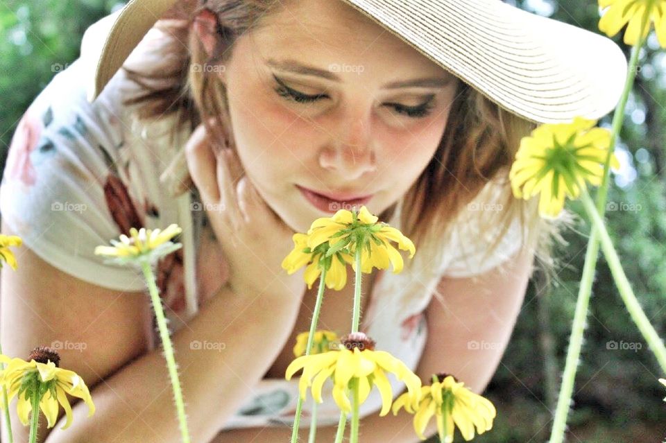 Stop and smell the flowers- a women smelling flowers 
