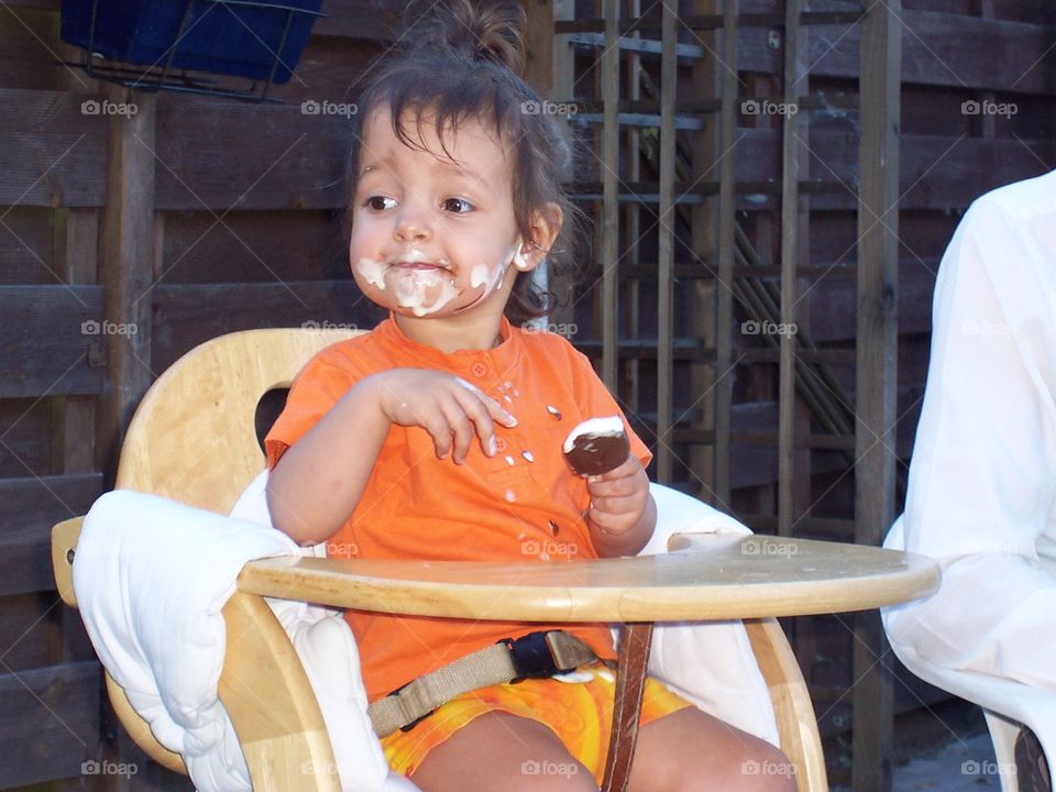 Baby girl smudging her icecream all over her face