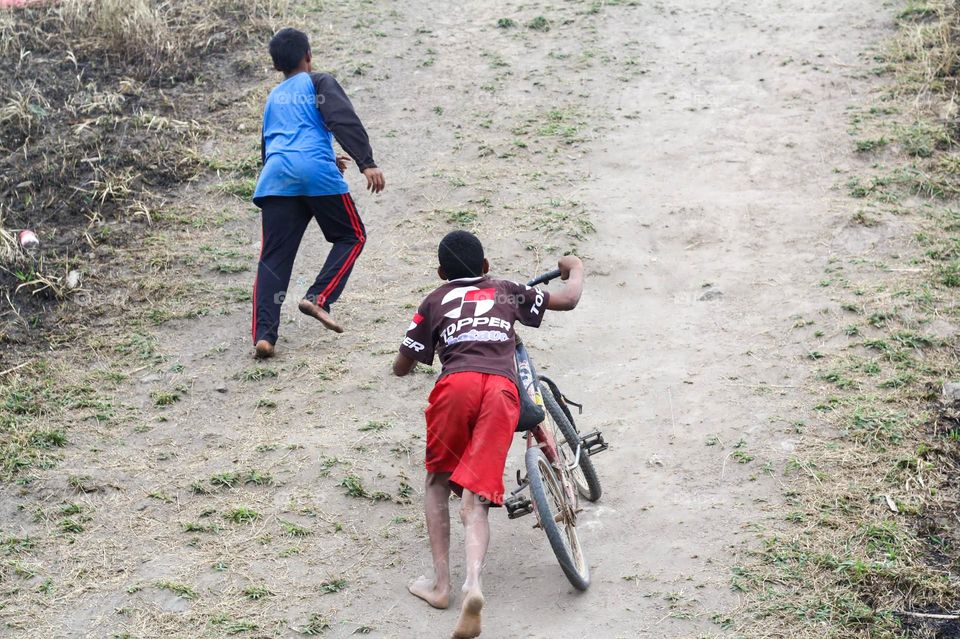 two boys playing with their bicycle