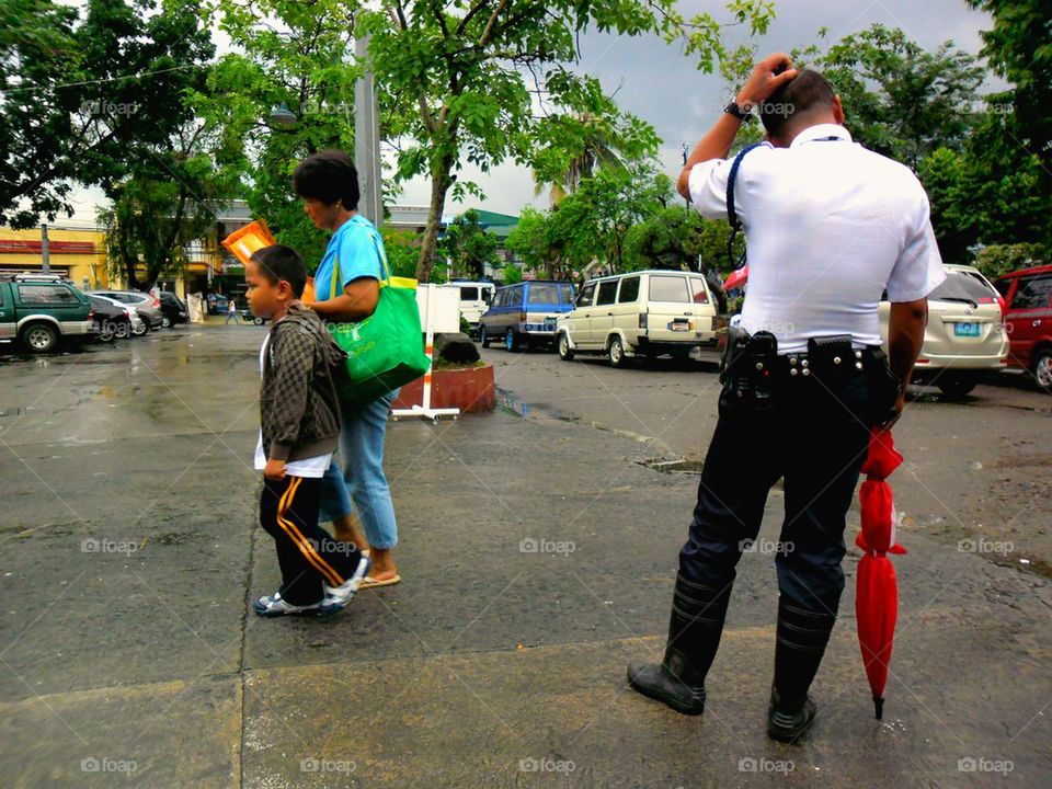 mother fetching her child from school and walks by the school security guard