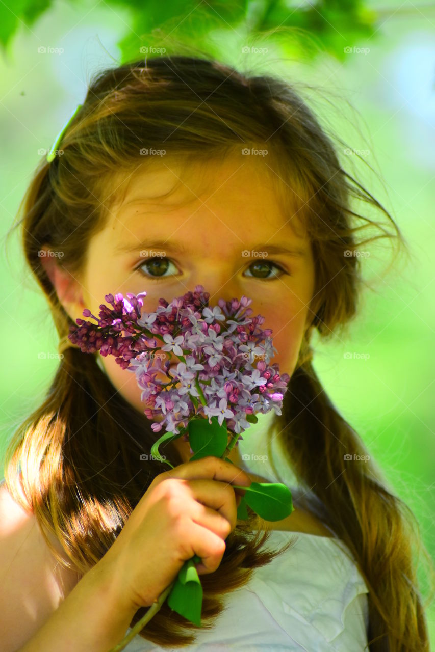 girl smelling lilacs
