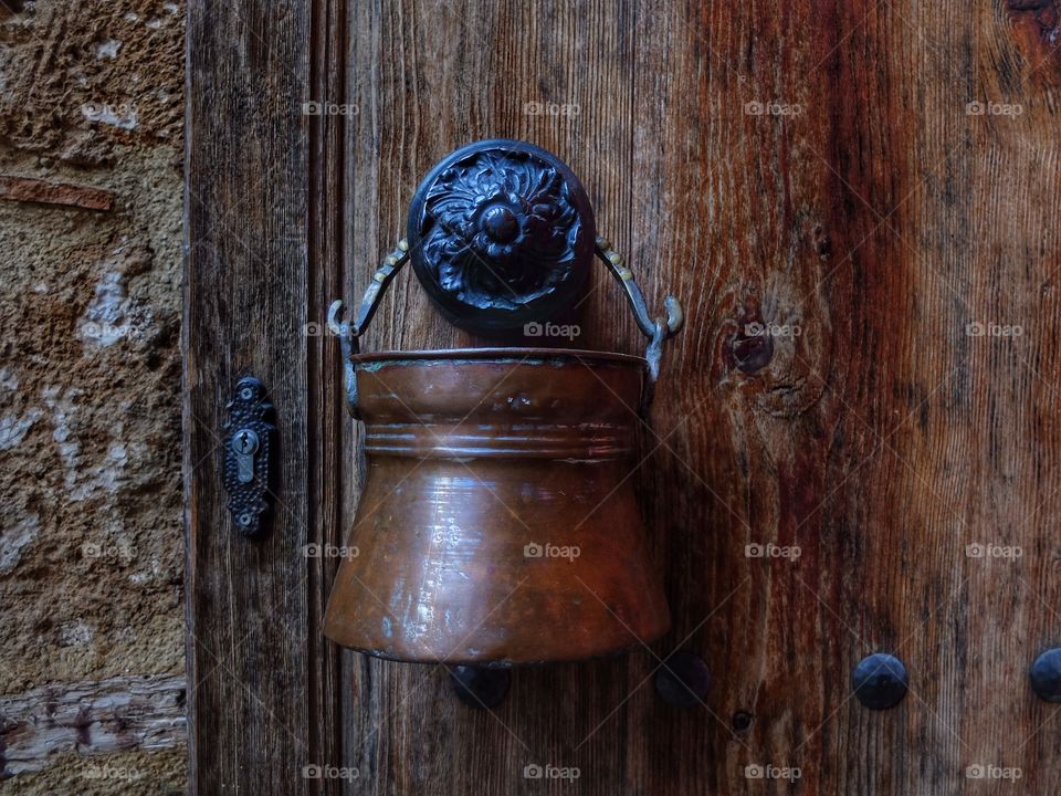A bronze bucket. . Passing by one of the restaurants in Antalia I saw that small bucket over a door handle. I thought it's nice object