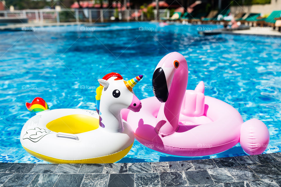 Inflatable flamingo and unicorn in swimming pool 