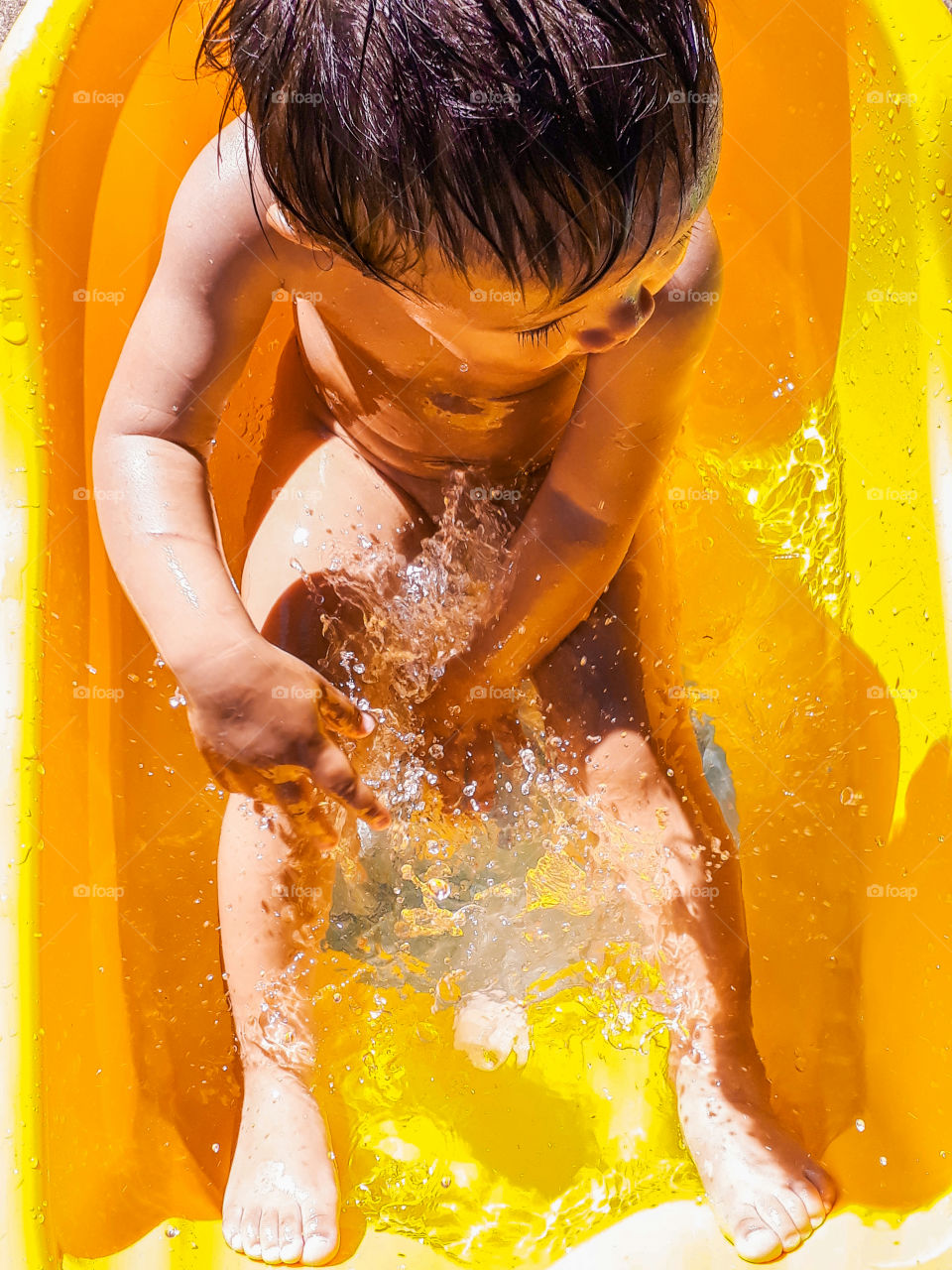 A kid enjoying an outdoor bathtub fun on a hot sunny day