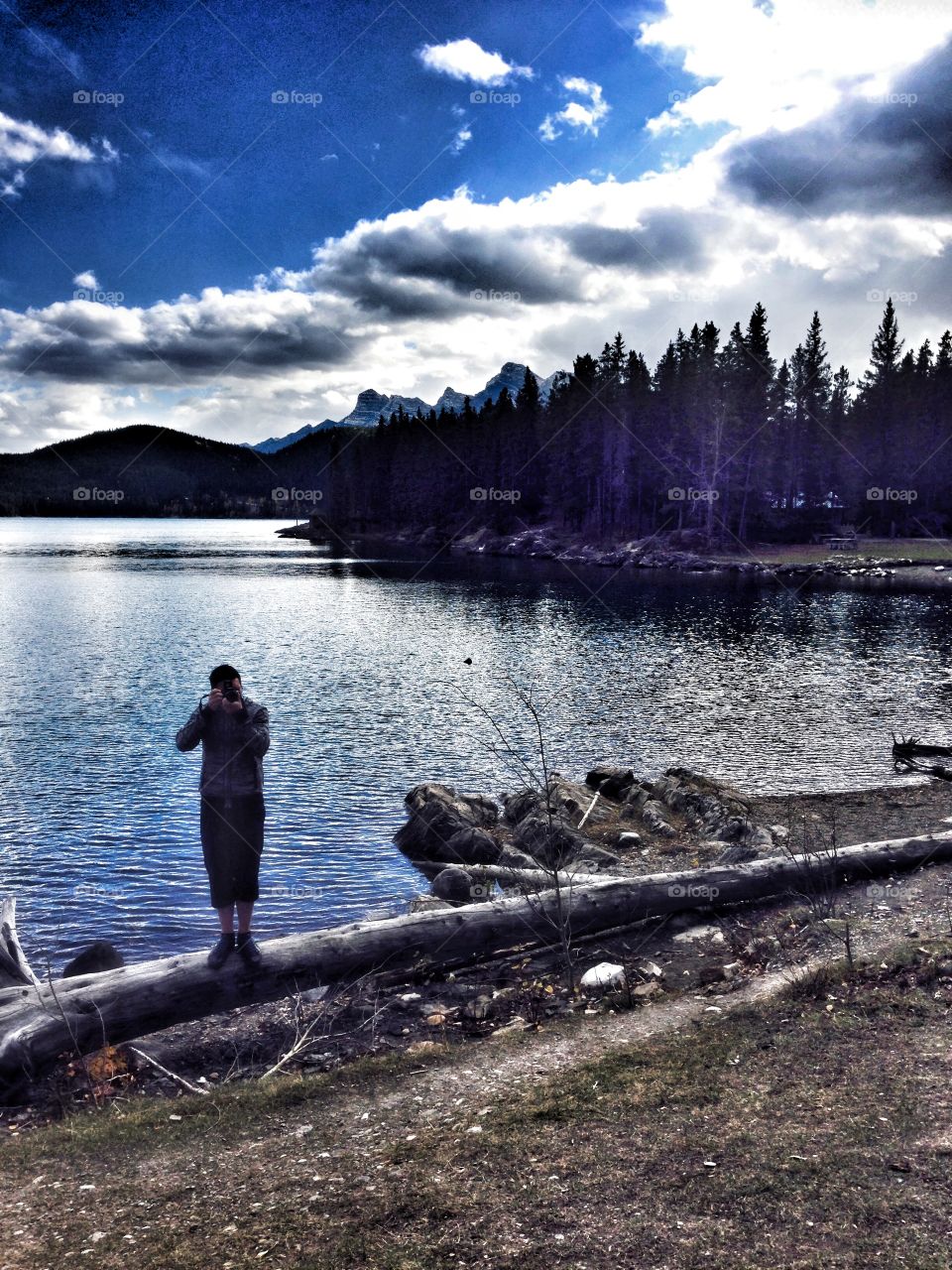 Family taking pictures of each other enjoying The Rockies in Canada. 