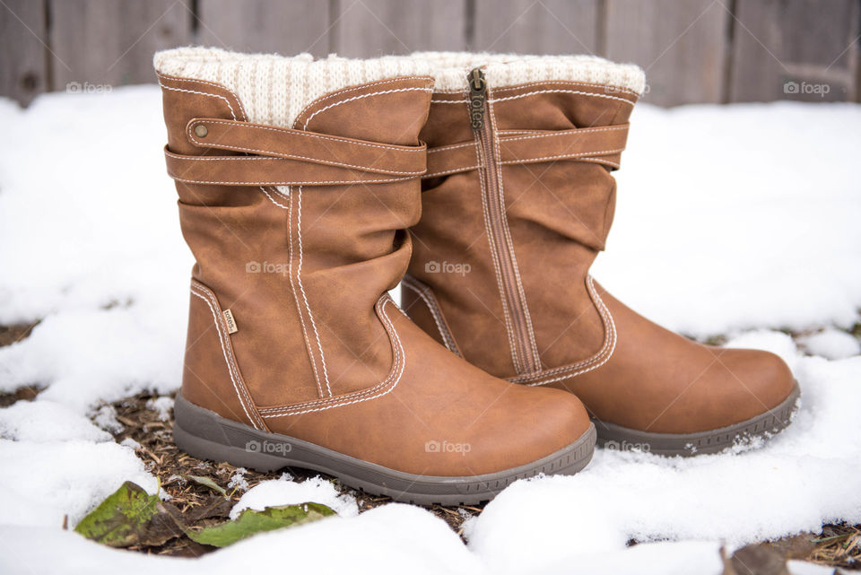 Close-up of a pair of women's boots in the snow outdoors