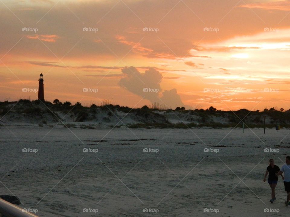 Lighthouse. Sunset on the beach near the lighthouse 