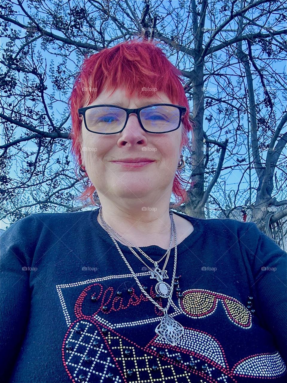 This is me, „Petra Schiller“ a.k.a. „Maxine Firefox“ standing outside on the front deck of „Salvation“ at „Newtown Creek“ by the „Pulaski Bridge“ in LIC, Queens against a backdrop of trees on the strip of land nearby. 2024. Hypnotic Productions