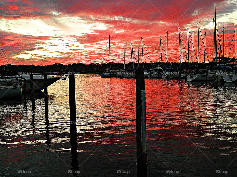Sunset at the marina- sailboats sway as the water current pushes them from side to side as they bask in the glory of this magnificent sunset 