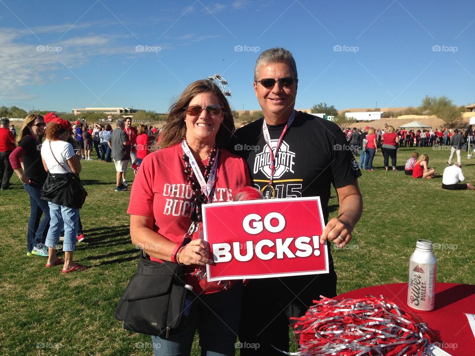 Man and woman holding cardboard with go bucks text