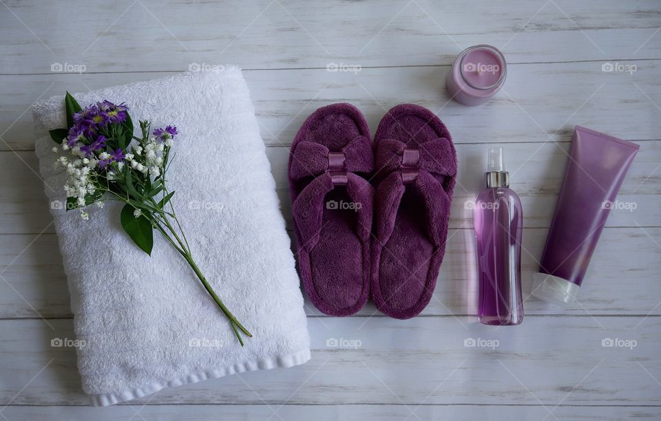 Purple Isotoner bath slippers on a wood floor 