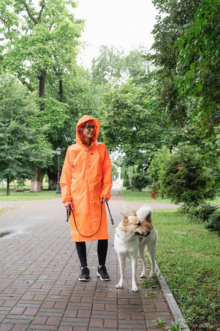 woman walking the dog in rainy day