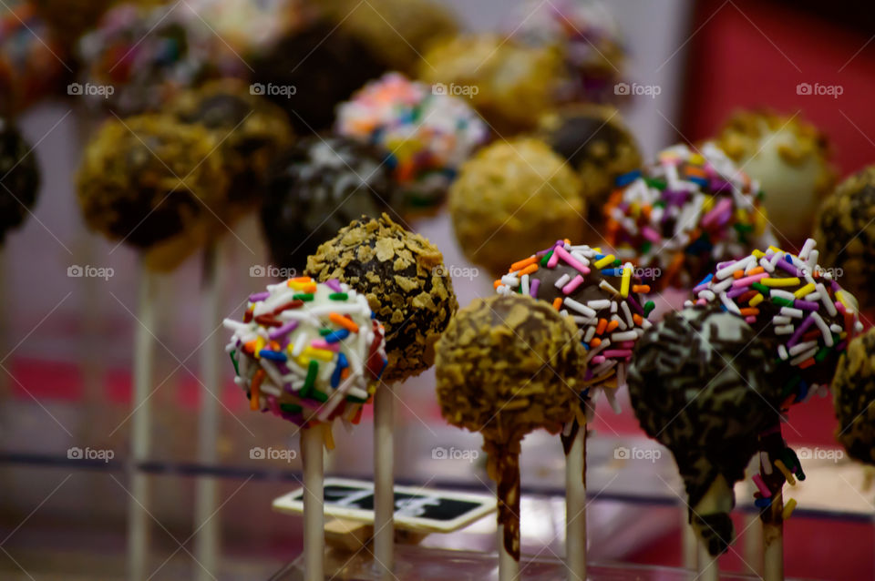 Gourmet chocolate cake pops dessert with chocolate and colorful sprinkles in table conceptual party, gourmet dessert or bake sale background photography 