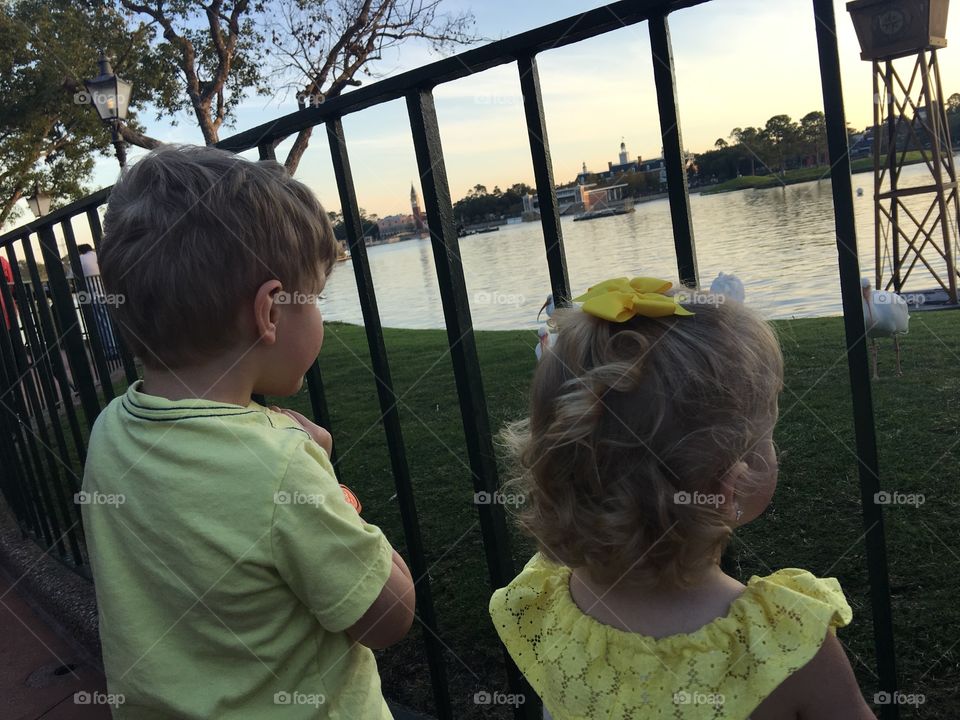 Matching siblings casually looking at the water in Disney World’s Epcot World showcase. 