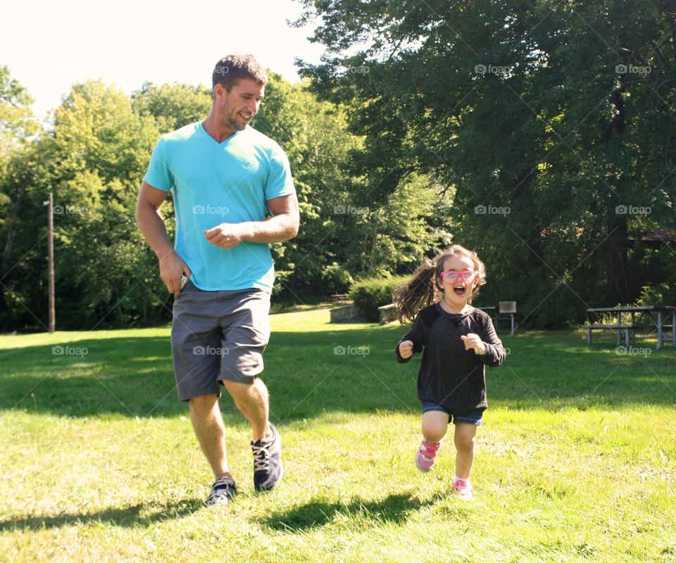 Father and daughter running in park
