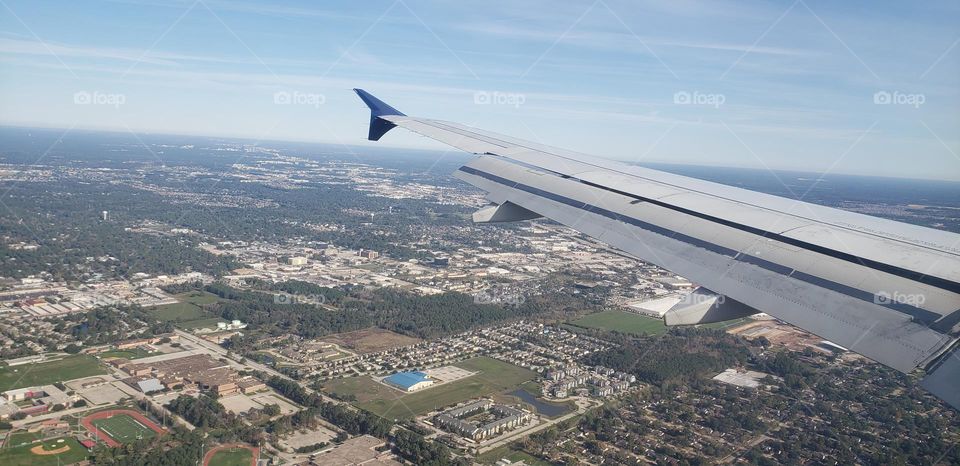 view of the wing and ground from an airplane window